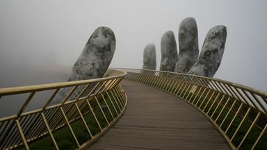 A bridge with a concrete hand holding it.